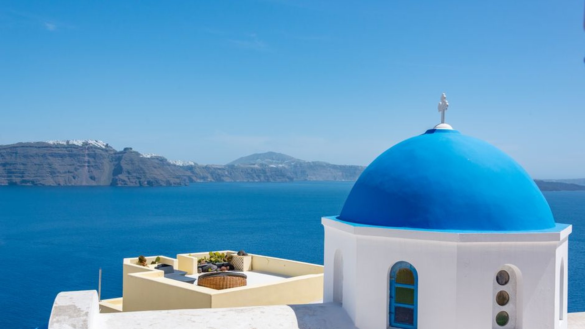 Santorini blue dome church stone alleyway sea view