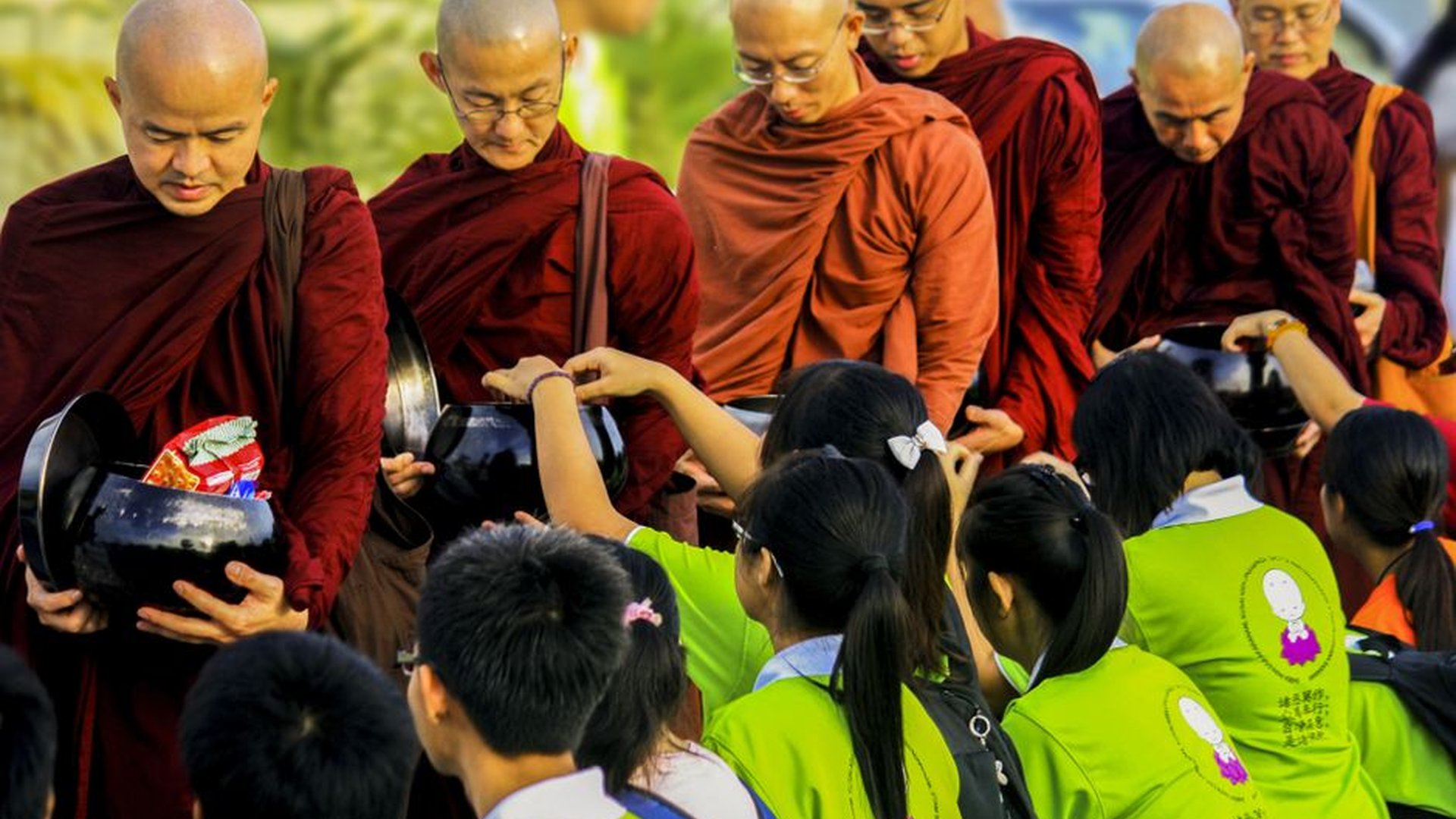 child laughing holding coconut monk offering alms